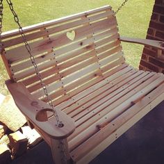 a wooden swing with chains attached to it