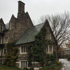 an old stone house with ivy growing on it's roof and windows, in the fall