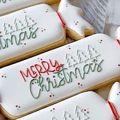 decorated christmas cookies sitting on top of a table next to each other with the words merry christmas written on them