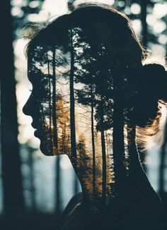 a woman's profile with trees in the background and sun shining through her hair