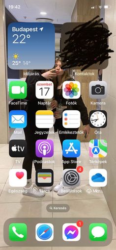 two people standing in front of an iphone with icons on the screen and behind them