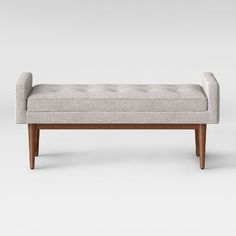 an upholstered bench with wooden legs