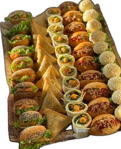 a long tray filled with lots of different types of sandwiches and wrappers on top of each other