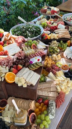 an assortment of cheeses, fruits and meats on a table