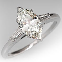 an oval cut diamond ring with baguettes on the side and tapered shoulders