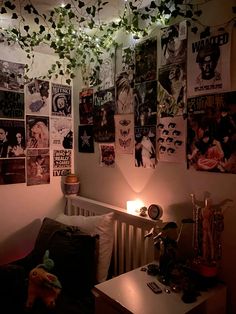 a bedroom with posters on the wall and a table in front of it, next to a lamp