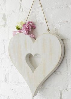 a wooden heart hanging on a wall with flowers in it and the words always react with love