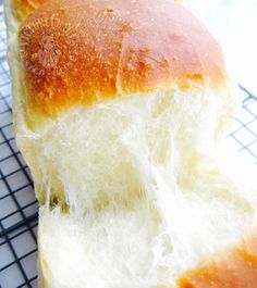 a loaf of white bread sitting on top of a cooling rack