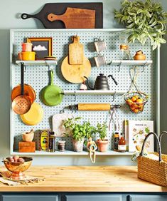 a kitchen counter with pots and pans hanging on it's pegboard,