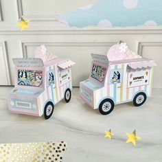 two small toy trucks are sitting on the floor next to gold stars and a white wall