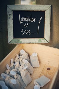 a wooden box filled with lots of white stuff next to a chalkboard that says lavender to toss