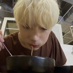 a young boy is eating from a bowl