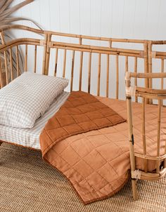 a bed with two pillows on top of it next to a bamboo headboard and foot board