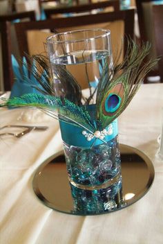 there is a peacock feather in a vase on the table