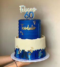 a blue and white cake with the number eighty on top is being held by a person