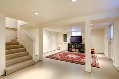 an empty living room with carpet and stairs