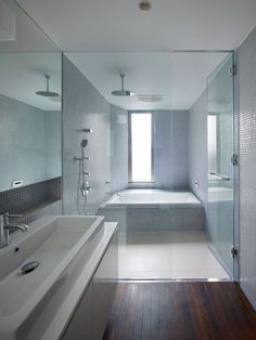 a bathroom with a large tub, sink and shower head mounted to it's wall