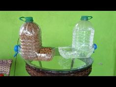 two plastic bottles sitting on top of a glass table next to a basket filled with nuts