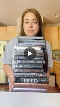 a woman holding a stack of books in front of her face