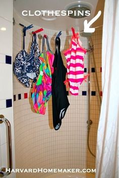 there is a shower with clothes hanging on the hooks