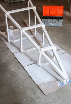 a wooden structure sitting on top of a piece of plywood