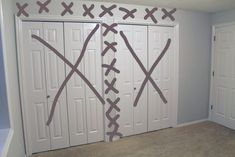 two white doors with crosses painted on them in a room that has carpeted flooring