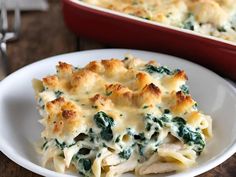 a casserole dish with chicken, spinach and cheese in it on a white plate