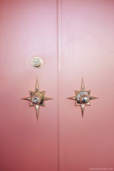 the door is pink and has two metal stars on it