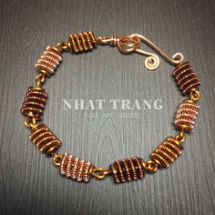 a gold and brown beaded bracelet on a wooden table