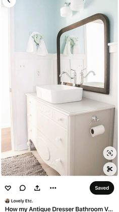 a bathroom with a sink, mirror and towel dispenser