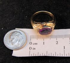 Exquisite 14 karat yellow gold ring semi-bezel set to the front with one oval-cut purple amethyst (approximately 3.02 carats) surrounded by 6 round-cut diamonds (each approximately .02 carats). The ring is unmarked, but acid tested positive as 14 karat gold and does not react to a magnet. It weighs approximately 6.2 grams. It is approximately a size 5 3/4, and can be re-sized to fit by your local jeweler. Excellent estate condition. We are listing several pieces of estate jewelry, along with oth Formal Purple Oval Ruby Ring, Amethyst And Diamond Ring, Diamonds Ring, Wilmington Nc, February Birthstone, February Birth Stone, Yellow Gold Ring, Round Cut Diamond, Purple Amethyst