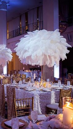 the tables are decorated with white feathers and candles for an elegant event or functional