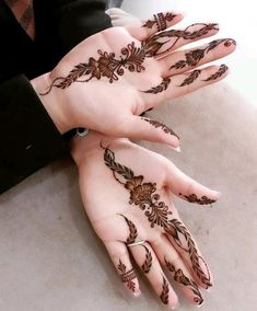 two hands with henna tattoos on them