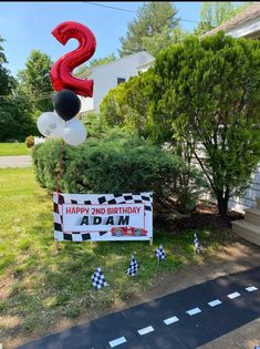 a birthday sign is in front of a house with balloons and streamers on the lawn