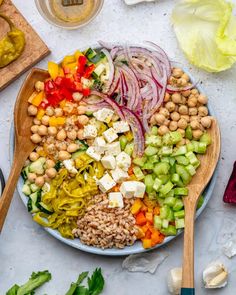 a plate filled with vegetables and chickpeas on top of a table next to other ingredients