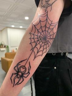 a man with a spider web tattoo on his arm