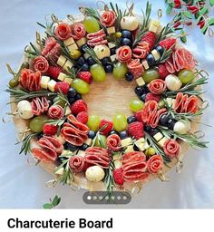 an arrangement of fruits and vegetables arranged in the shape of a wreath on top of a table