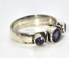 Tanzanite three stone thick solid sterling silver boho gemstone ring band. Good used condition with little signs of normal wear. Great patina present. Bezel set gemstones. Stamped 925 on the inside of the band. Acid tests positive for sterling silver. Gemstones tested with Presidium II gemstone tester. Ring measures size 9. Unique Silver Three Stone Jewelry, Unique Silver Jewelry With Three Stones, Unique Silver Three-stone Jewelry, Unique Sterling Silver Ring With Three Stones, Silver Tanzanite Ring With Center Stone, Silver Tanzanite Birthstone Ring With Accent Stones, Anniversary Three-stone Tanzanite Jewelry, Spiritual Sterling Silver Multi-stone Rings, Silver Tanzanite Multi-stone Rings