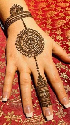 a woman's hand with henna tattoos on it