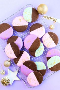 some cookies are sitting on a cooling rack next to christmas ornaments and decorations, with a merry sign in the background