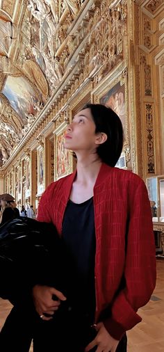 a woman is looking up at the ceiling in a room with ornate paintings on it