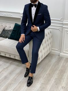 a man in a tuxedo is sitting on a white couch wearing black shoes