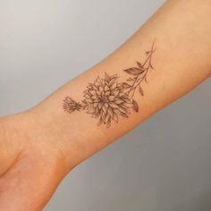 a woman's arm with a flower tattoo on it