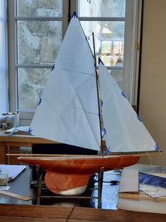 a model sailboat sitting on top of a wooden table