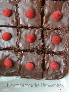 chocolate brownies with raspberries on top are arranged in squares and placed on a plate