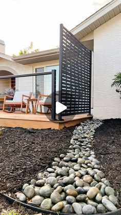 a house that has rocks in front of it and a deck on the other side