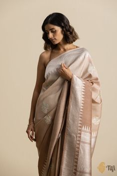 "Woven in the fine weaving techniques\u00a0of Banaras, this charming drape has beautiful bootas with floral design inspirations and Meenakari accents on textured\u00a0silk and shimmering roopa zari.\u00a0\n\n\n Color\u00a0- A\u00a0beautiful ombr\u00e9 of Beige and Brown\u00a0\n\nFabric\u00a0- Textured in appearance, pure Tussar by Georgette silk\u00a0\n\nTechnique - An enduring Kadwa weave. This elaborate and laborious technique involves hand-weaving each motif separately. It takes longer on the Brown Fabric Texture, Silk Banarasi Saree, Banarasi Sarees, Handloom Saree, Weaving Techniques, Coral Pink, Blouse Piece, Fabric Texture, Desi