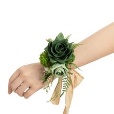 a woman's arm with a wrist corsage and green flowers on it