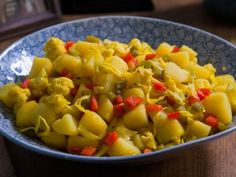 a blue bowl filled with food on top of a wooden table