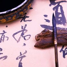 a knife and some writing on a table next to a bowl with chopsticks